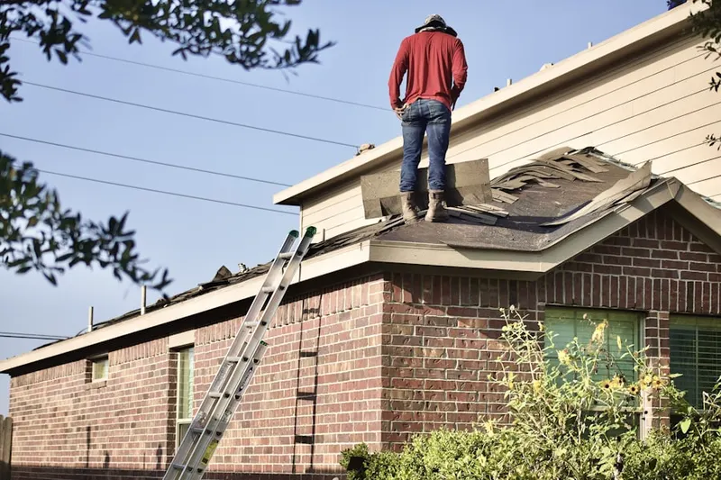 Professional roofer working on a residential roof in Legacy